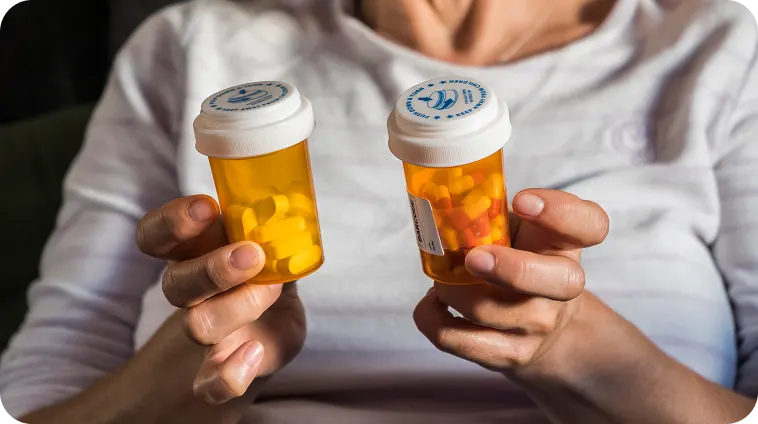 woman-holding-two-prescription-pill-bottles